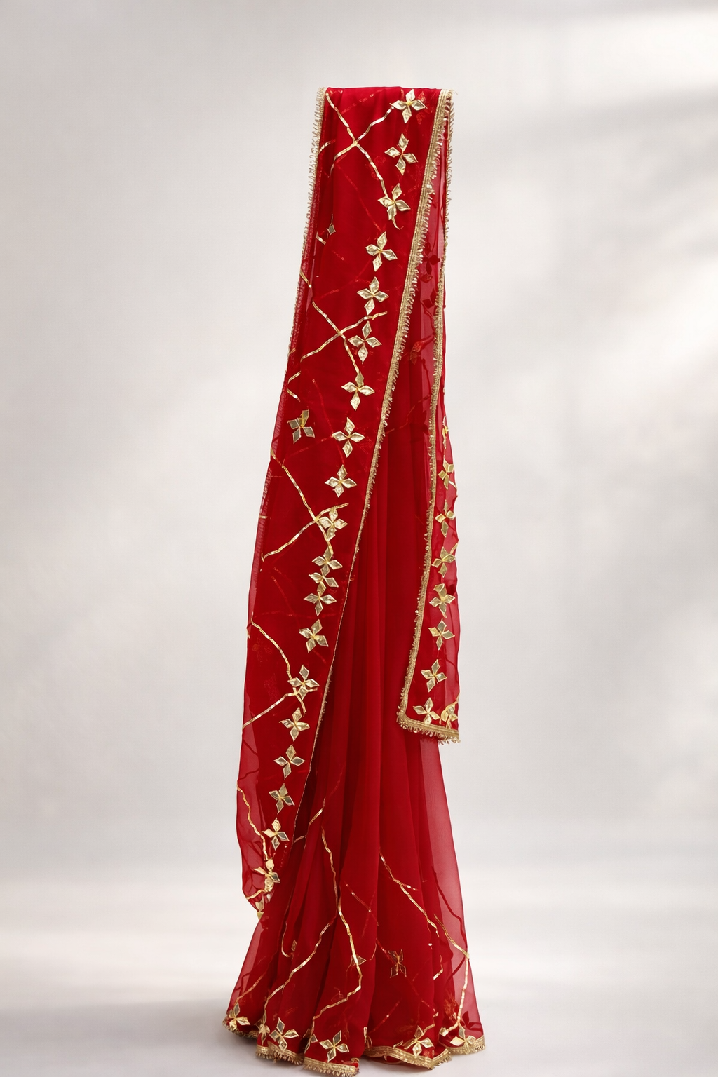 Red saree with gold embroidery on a white background