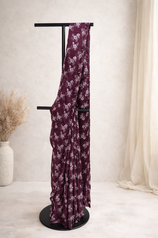 Purple floral fabric draped over a black stand against a white background